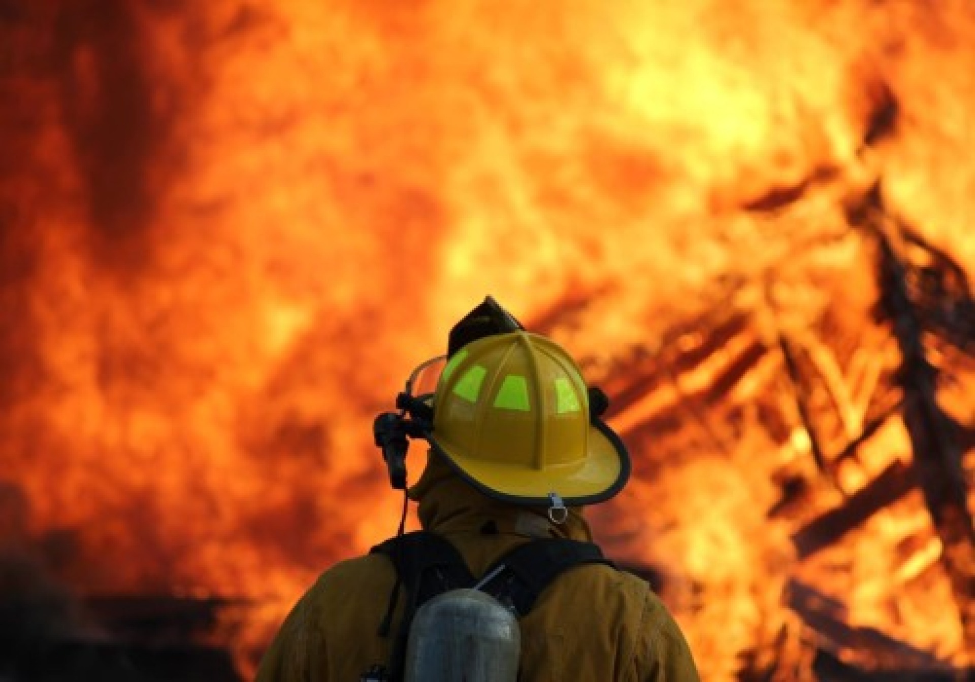 Firefighter looking at a blazing fire